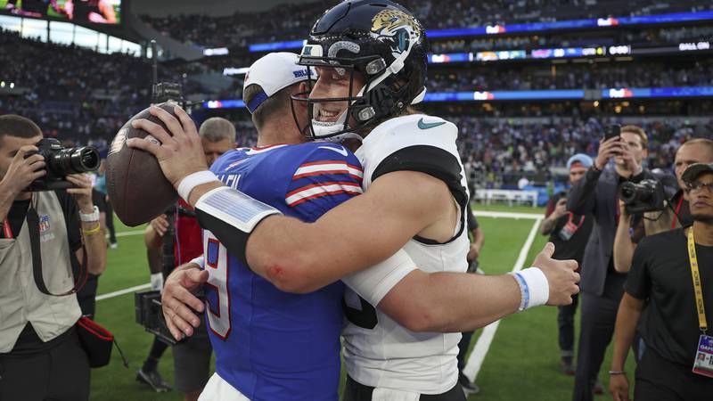 Jacksonville Jaguars quarterback Trevor Lawrence (16) greets Buffalo Bills quarterback Kyle...